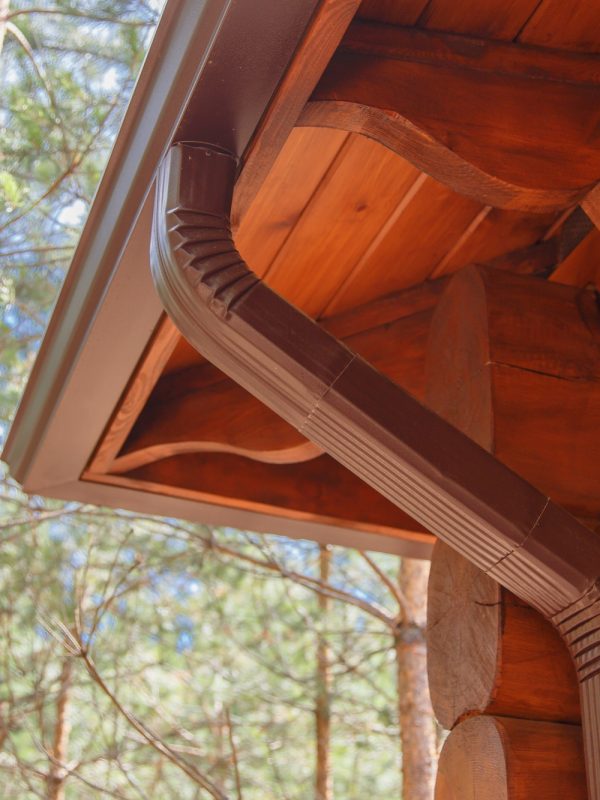 Roof gutter system on log house in forest Roof gutter system on log house in forest